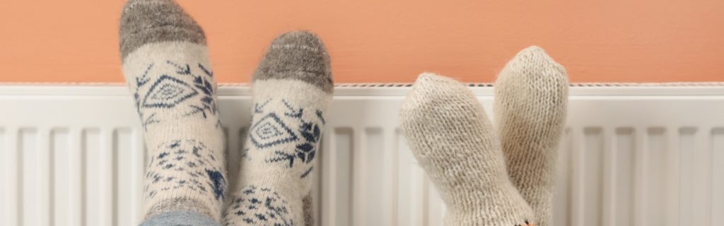 Picture of couple warming feet on a radiator